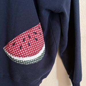 Hollister navy hoodie with fruit applications on back.